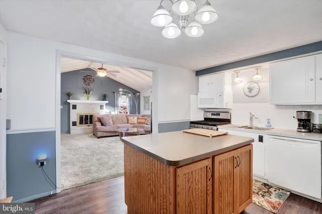 a kitchen with a sink appliances cabinets and furniture