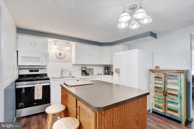 a kitchen that has a cabinets a stove a sink and a refrigerator