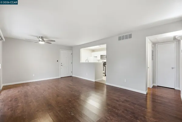 a view of an empty room with wooden floor