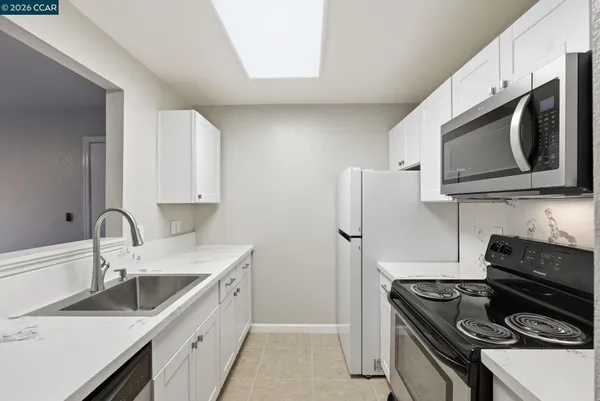 a kitchen with stainless steel appliances granite countertop a sink stove and microwave