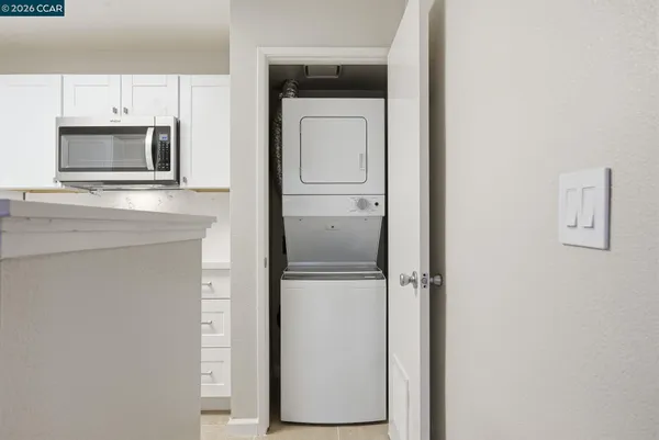 a view of a kitchen with white cabinets and stainless steel appliances