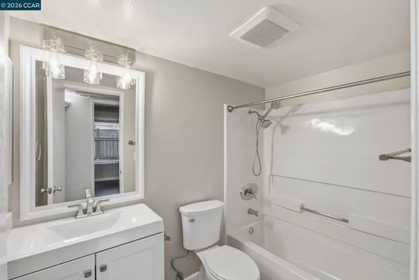 a bathroom with a sink vanity mirror and toilet