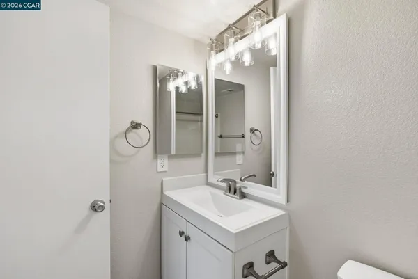a bathroom with a sink mirror and toilet