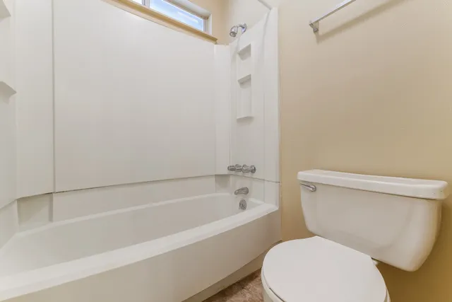 a white toilet sitting next to a bath tub