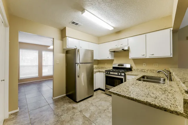 a kitchen with a refrigerator sink and stove