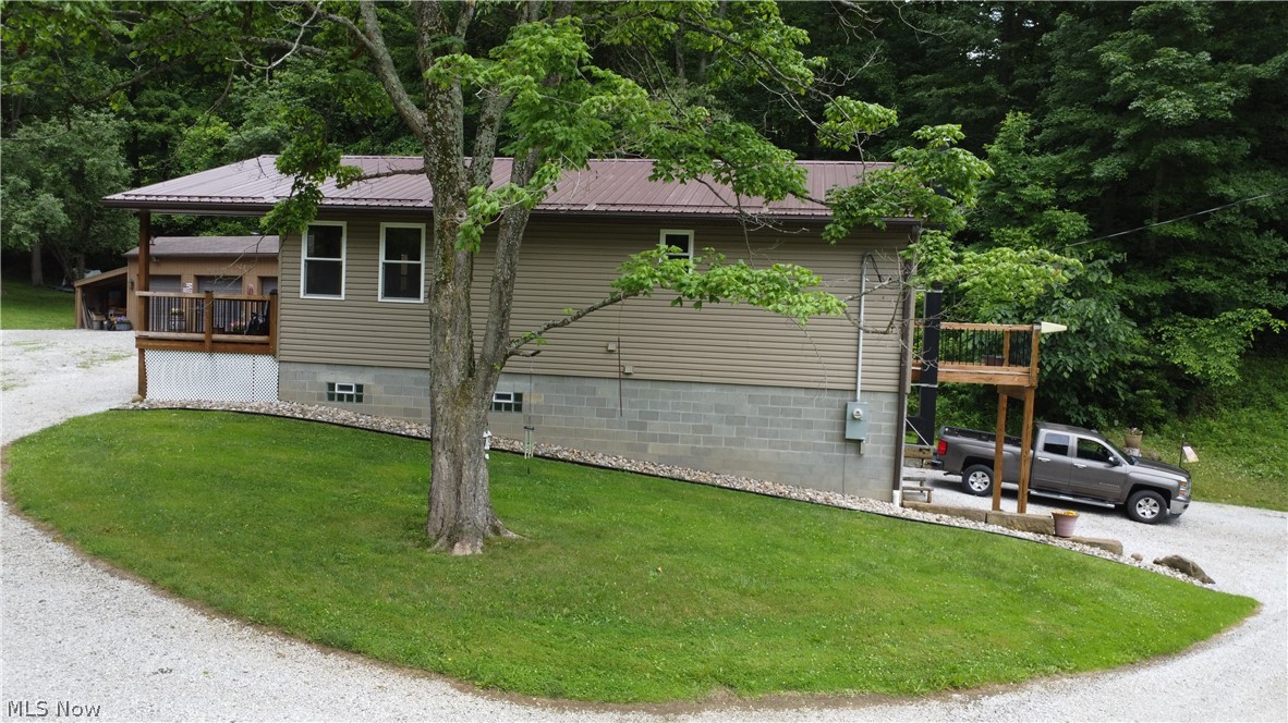 View of side of home featuring a yard