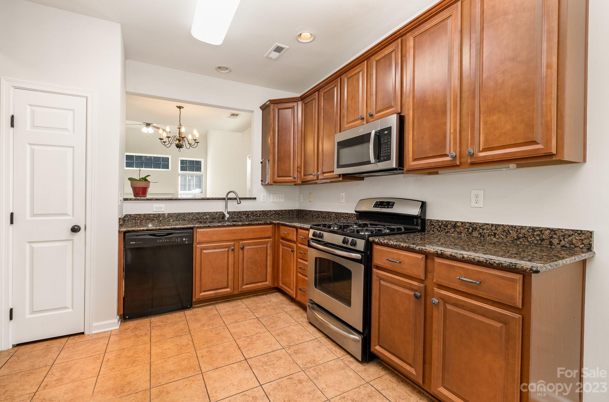 717 Prospect Lane Fort Mill, SC 29708 - Photo 5 of 21 a kitchen with stainless steel appliances granite countertop a stove top oven a sink dishwasher and cabinets with wooden floor