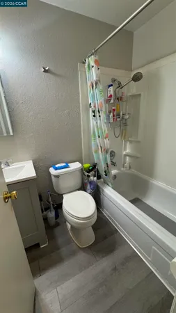 a white toilet sitting next to a bath tub