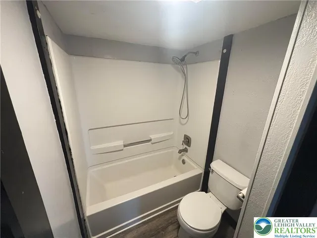 a bathroom with a toilet and a shower