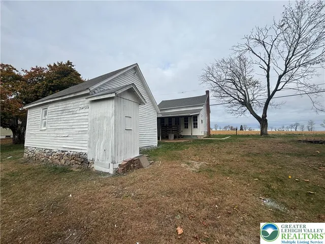 a view of house with backyard and trees