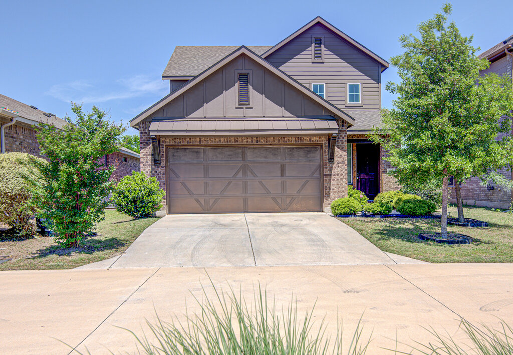 a front view of a house with a yard and garage
