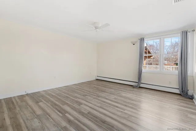 a view of an empty room with wooden floor