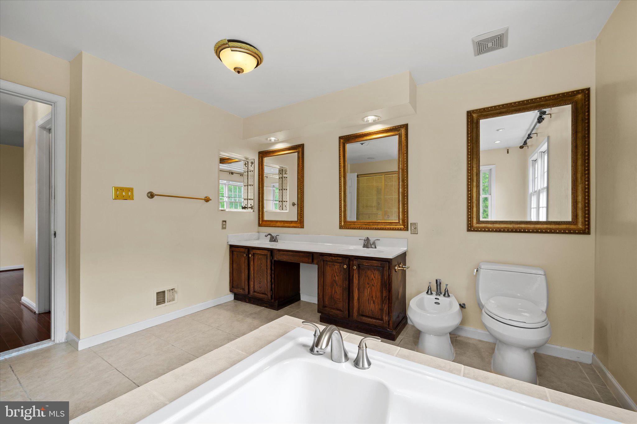 6832 Compton Heights Circle Clifton, VA 20124 - Photo 32 of 54 a spacious bathroom with a double vanity sink a toilet and a mirror