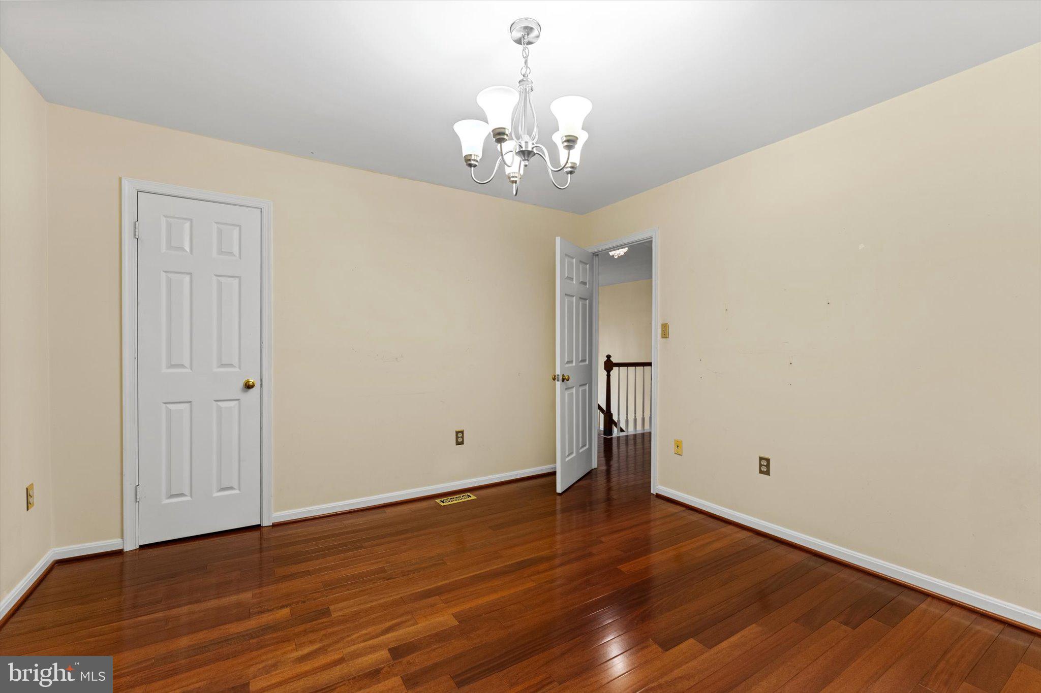6832 Compton Heights Circle Clifton, VA 20124 - Photo 34 of 54 a view of an empty room with wooden floor and a chandelier