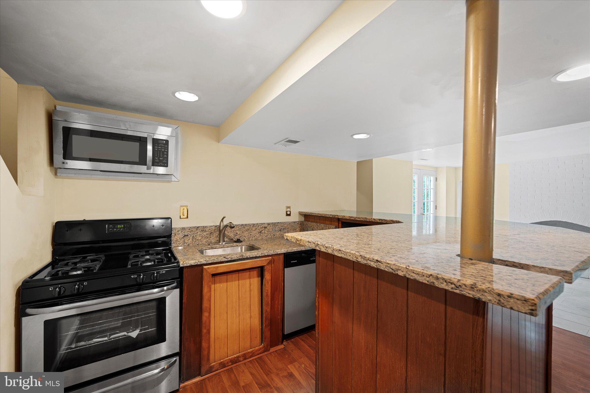 6832 Compton Heights Circle Clifton, VA 20124 - Photo 48 of 54 a kitchen with stainless steel appliances granite countertop a stove a sink and a microwave