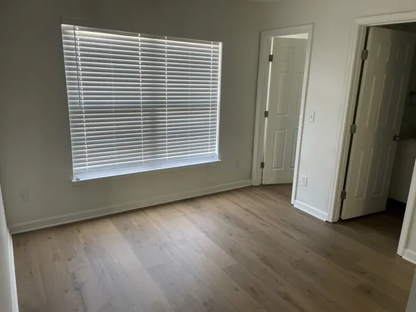 an empty room with wooden floor and a window