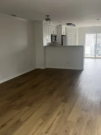 a view of a kitchen with wooden floor and a window