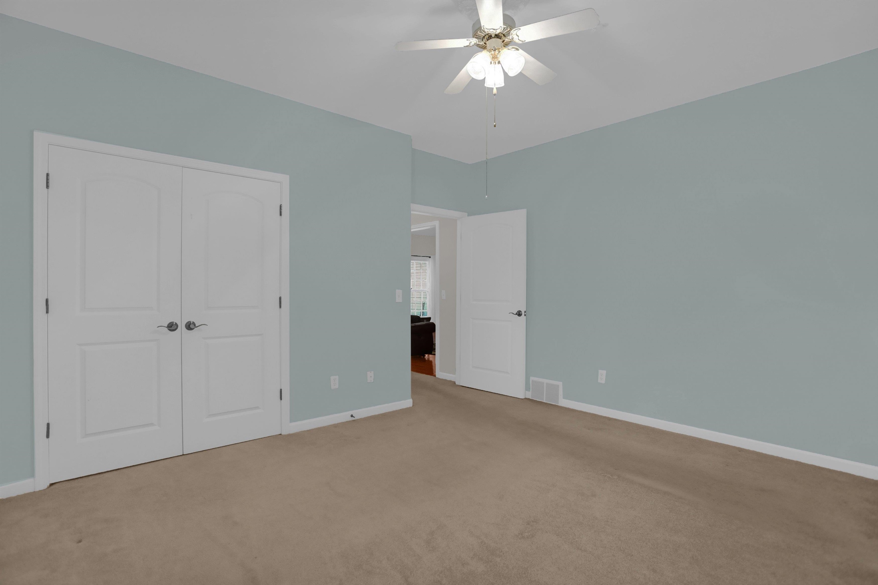 34 Peyton Ridge Drive, Unit 21 Collierville, TN 38017 - Photo 24 of 37 Interior space featuring light blue walls, a ceiling fan with integrated lighting, and neutral-toned carpeting
