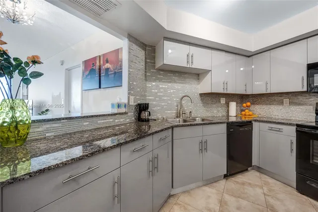 a kitchen with granite countertop a sink stainless steel appliances and cabinets