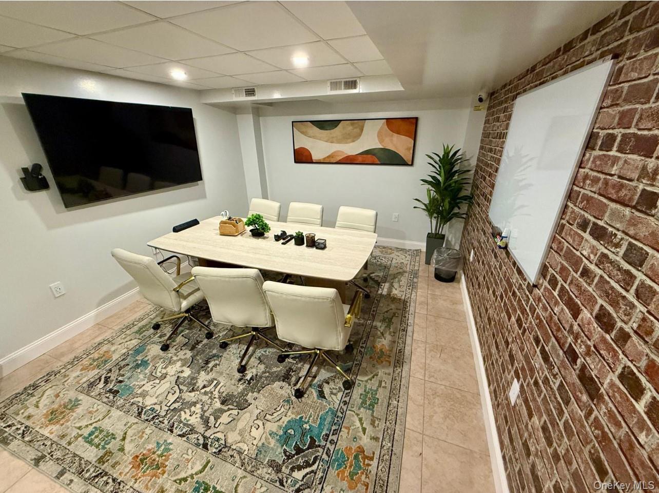 230 Pelham Road, Unit 2E New Rochelle, NY 10805 - Photo 18 of 31 Dining room featuring brick wall, light tile patterned floors, and an accent wall
