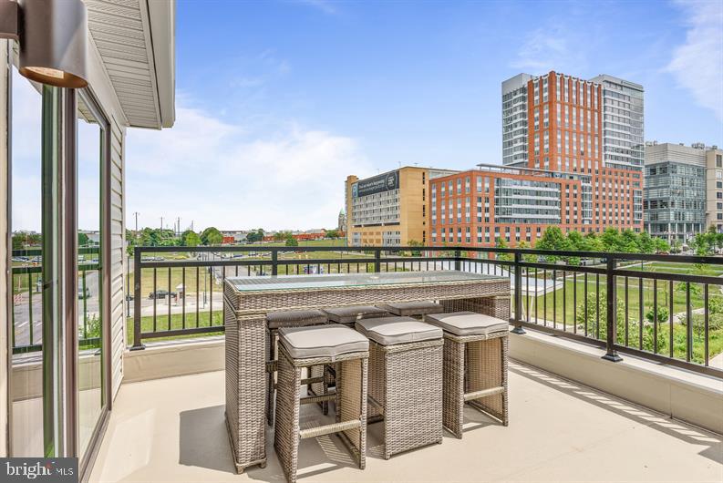 Kloman Street, Unit MOZART 3 Baltimore, MD 21230 - Photo 23 of 27 a view of a balcony with a table and chairs and wooden floor
