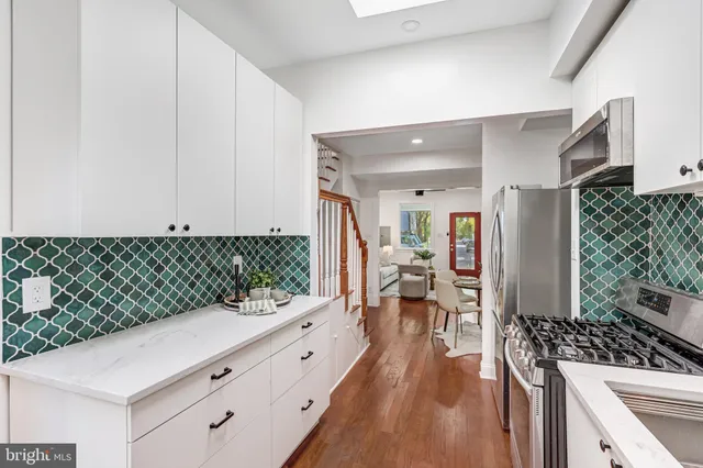 a kitchen with granite countertop a stove a chimney a sink and cabinets