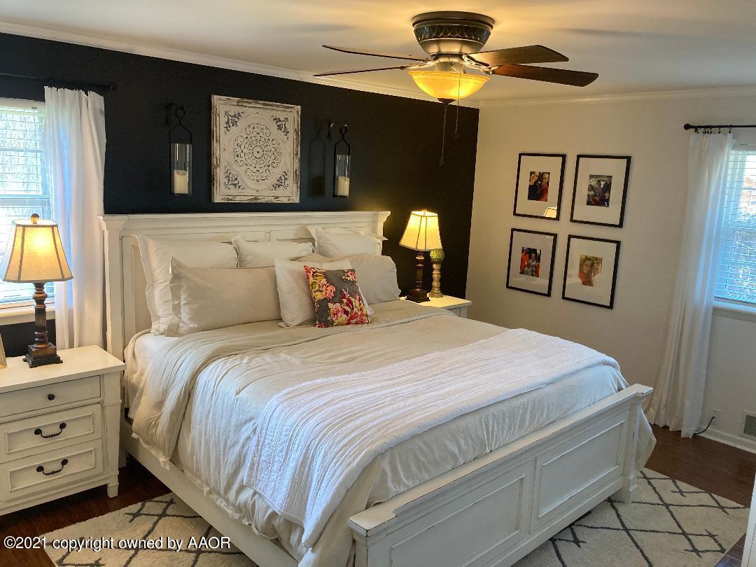 6717 Jameson Road Amarillo, TX 79106 - Photo 52 of 72 a bedroom with a bed and a chandelier