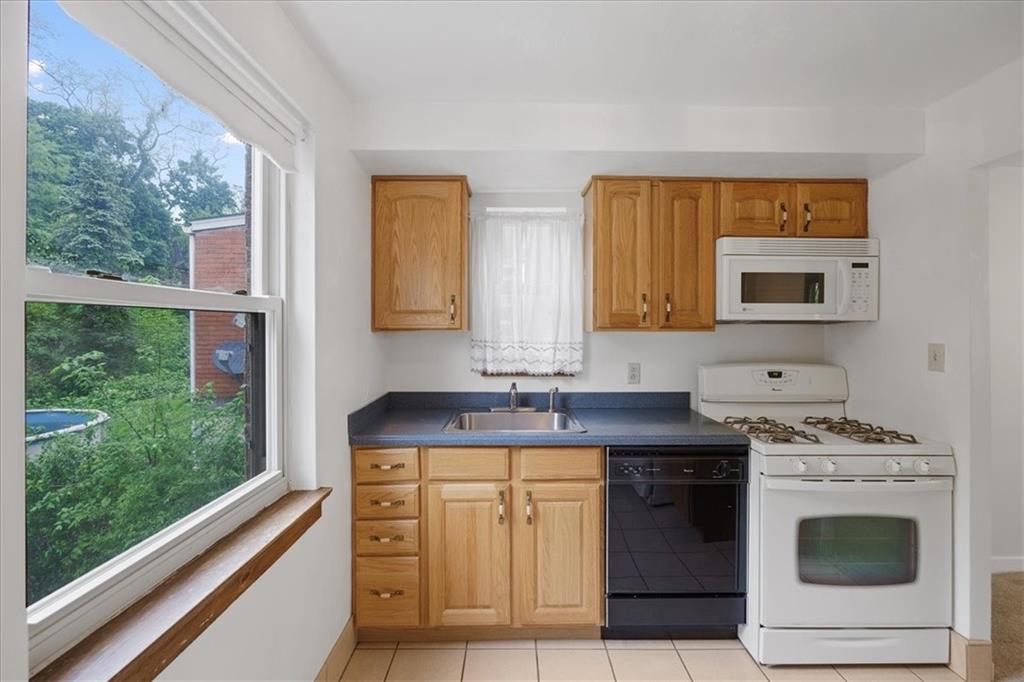 620 Beulah Road Pittsburgh, PA 15235 - Photo 10 of 25 a kitchen with stainless steel appliances granite countertop a stove a sink and a microwave