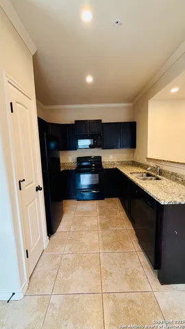 a kitchen with stainless steel appliances kitchen island granite countertop a refrigerator and a stove top oven