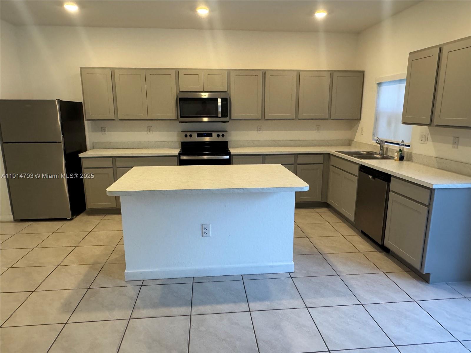 817 Northwest 3rd Way, Unit 817 Pompano Beach, FL 33060 - Photo 3 of 13 a kitchen with stainless steel appliances granite countertop a sink counter space and cabinets