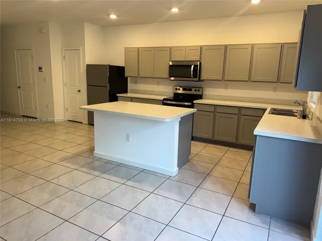 a kitchen with stainless steel appliances a stove a sink a microwave a counter top space and cabinets