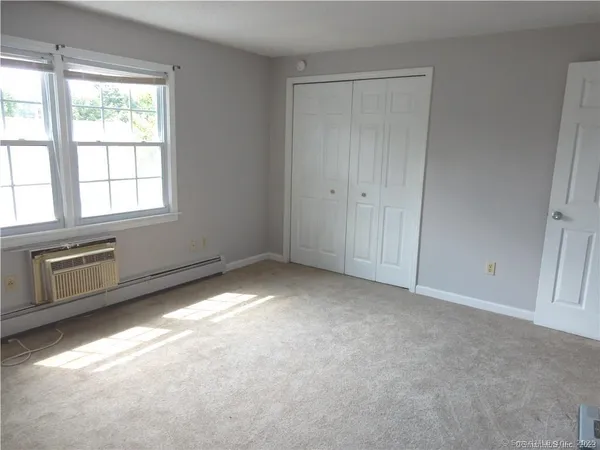 a view of an empty room with a fireplace and a window