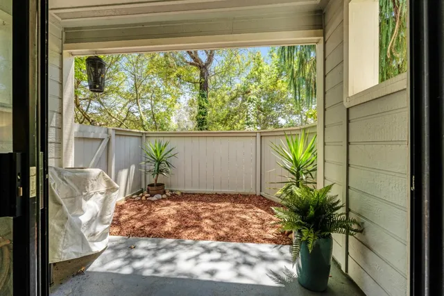 a view of a glass door with a chair and table in front of glass door