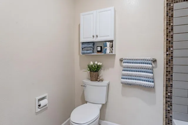 a bathroom with a toilet a sink and mirror