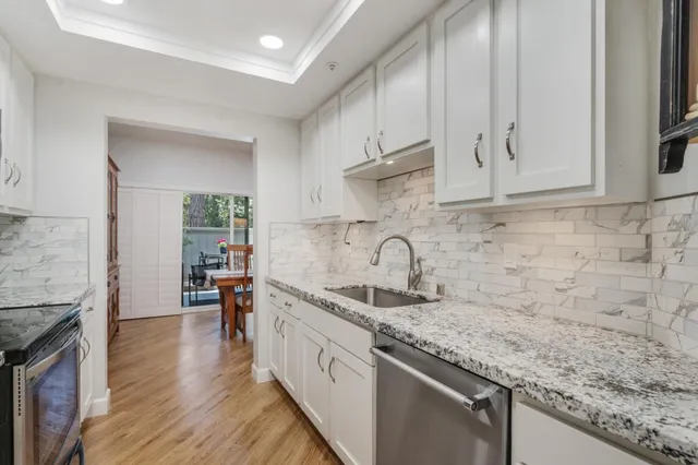 a kitchen with stainless steel appliances granite countertop a sink stove and cabinets