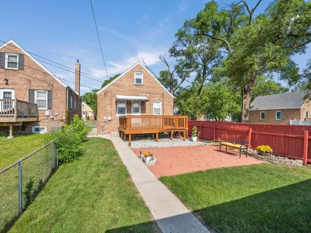 a view of a backyard with wooden fence and a bench