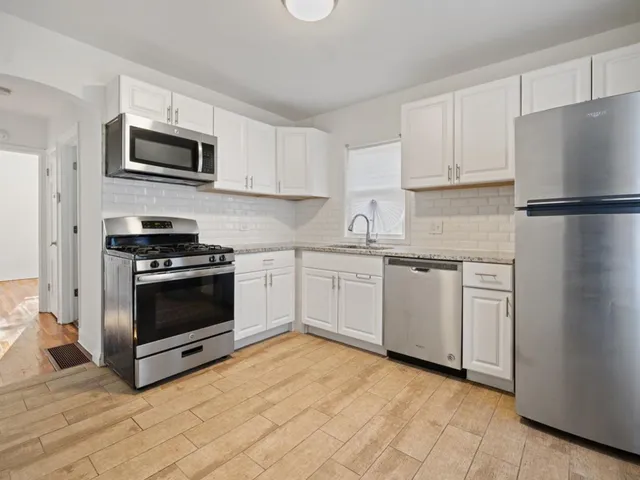a kitchen with white cabinets and stainless steel appliances