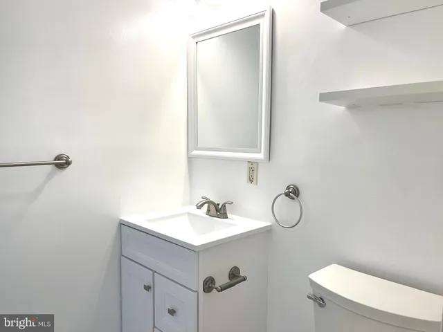 a bathroom with a sink mirror vanity and toilet