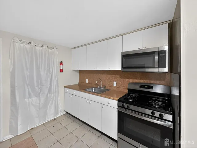a kitchen with stainless steel appliances a sink dishwasher stove and cabinets