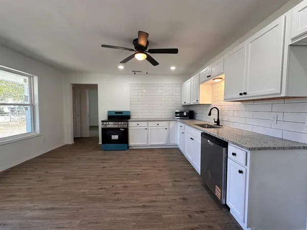a large kitchen with stainless steel appliances granite countertop a stove and a sink