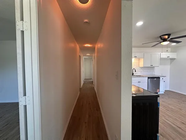 a view of a hallway with wooden floor