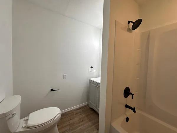 a white toilet sitting next to a bath tub