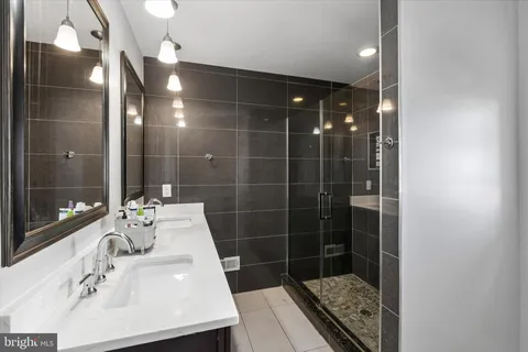 a bathroom with a sink shower and a mirror