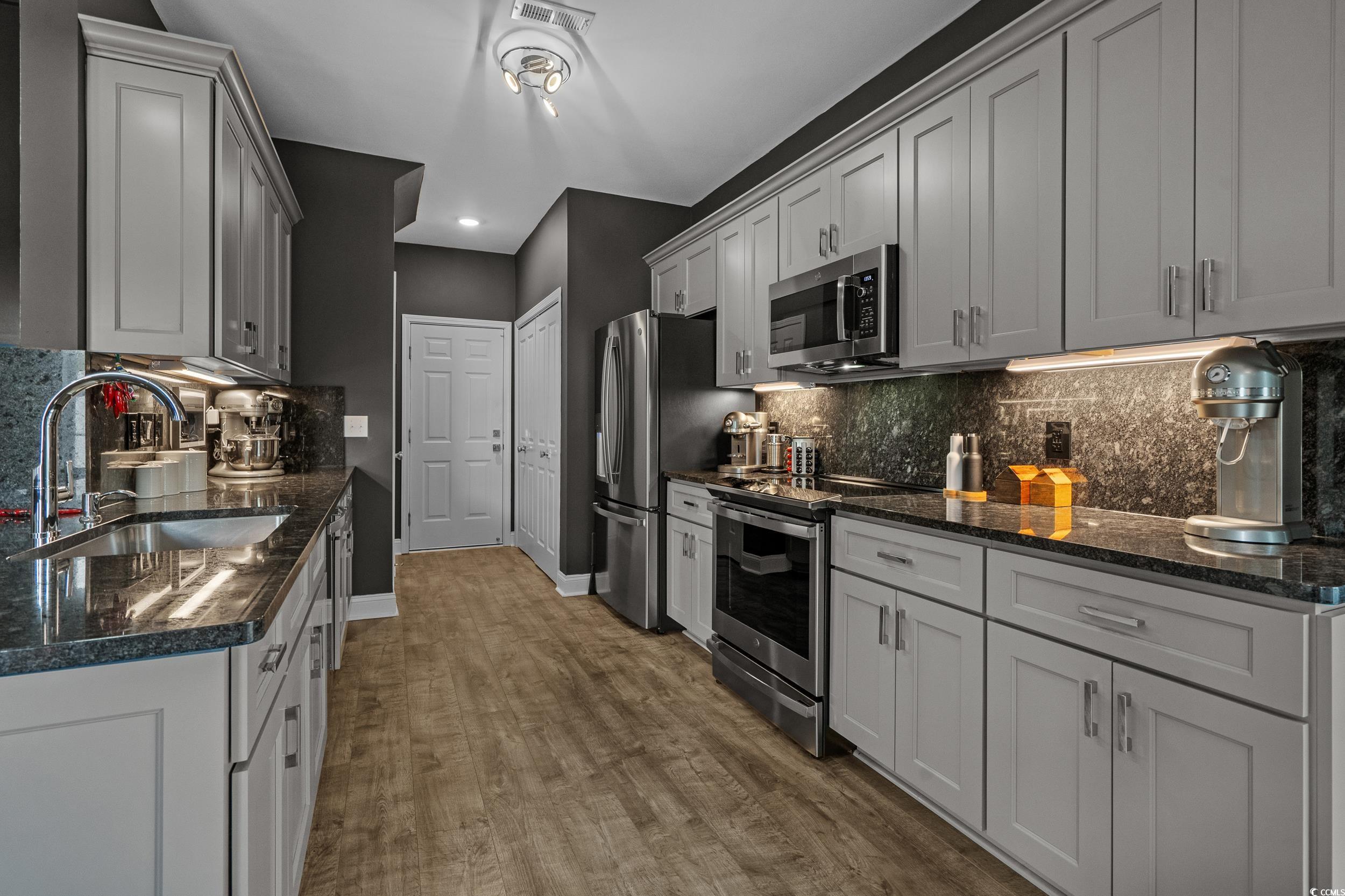 752 Hobonny Loop Longs, SC 29568 - Photo 15 of 40 Kitchen featuring stainless steel appliances, decorative backsplash, wood finished floors, recessed lighting, and dark stone counters