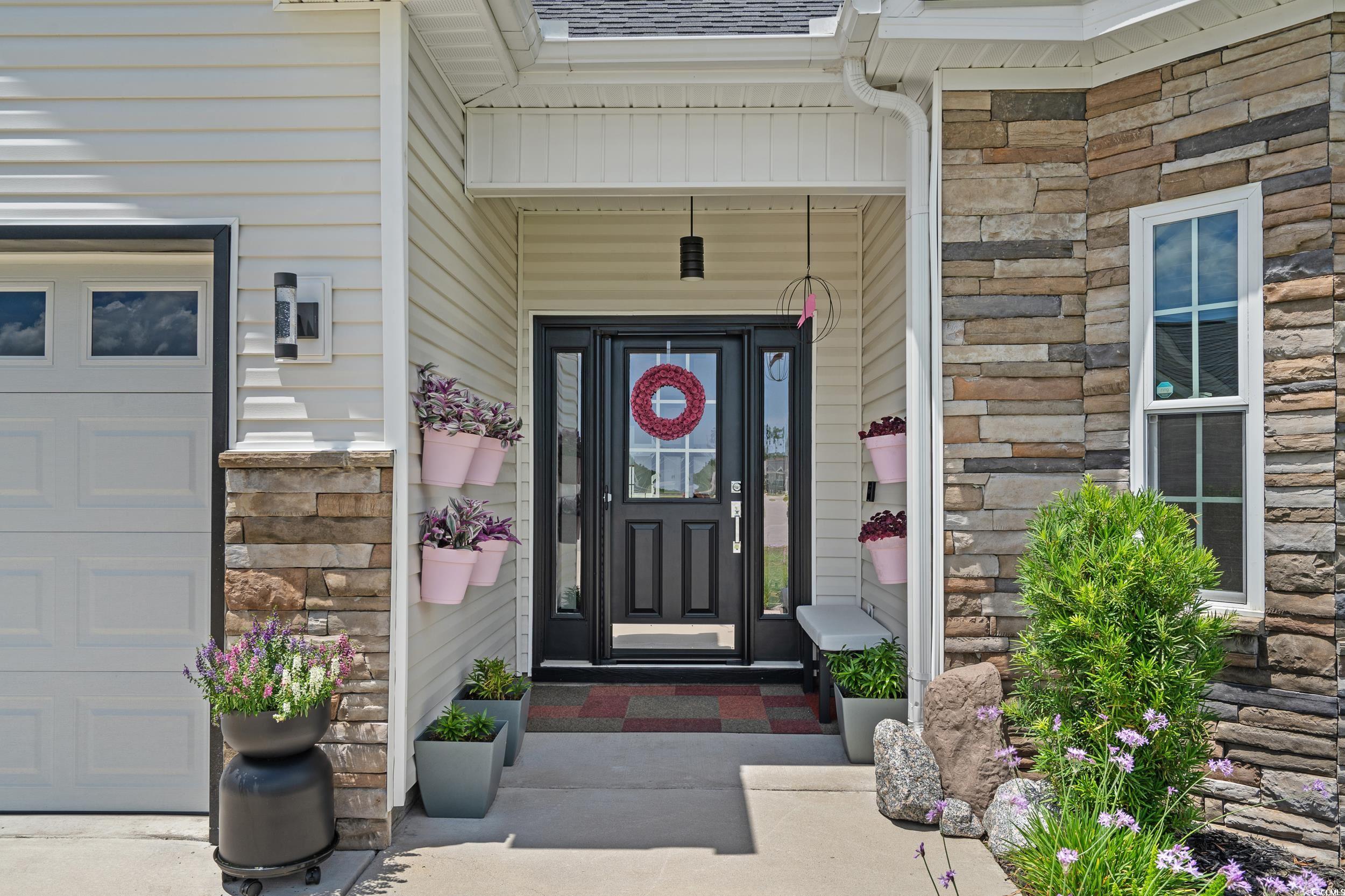 752 Hobonny Loop Longs, SC 29568 - Photo 2 of 40 View of exterior entry featuring stone siding and a shingled roof