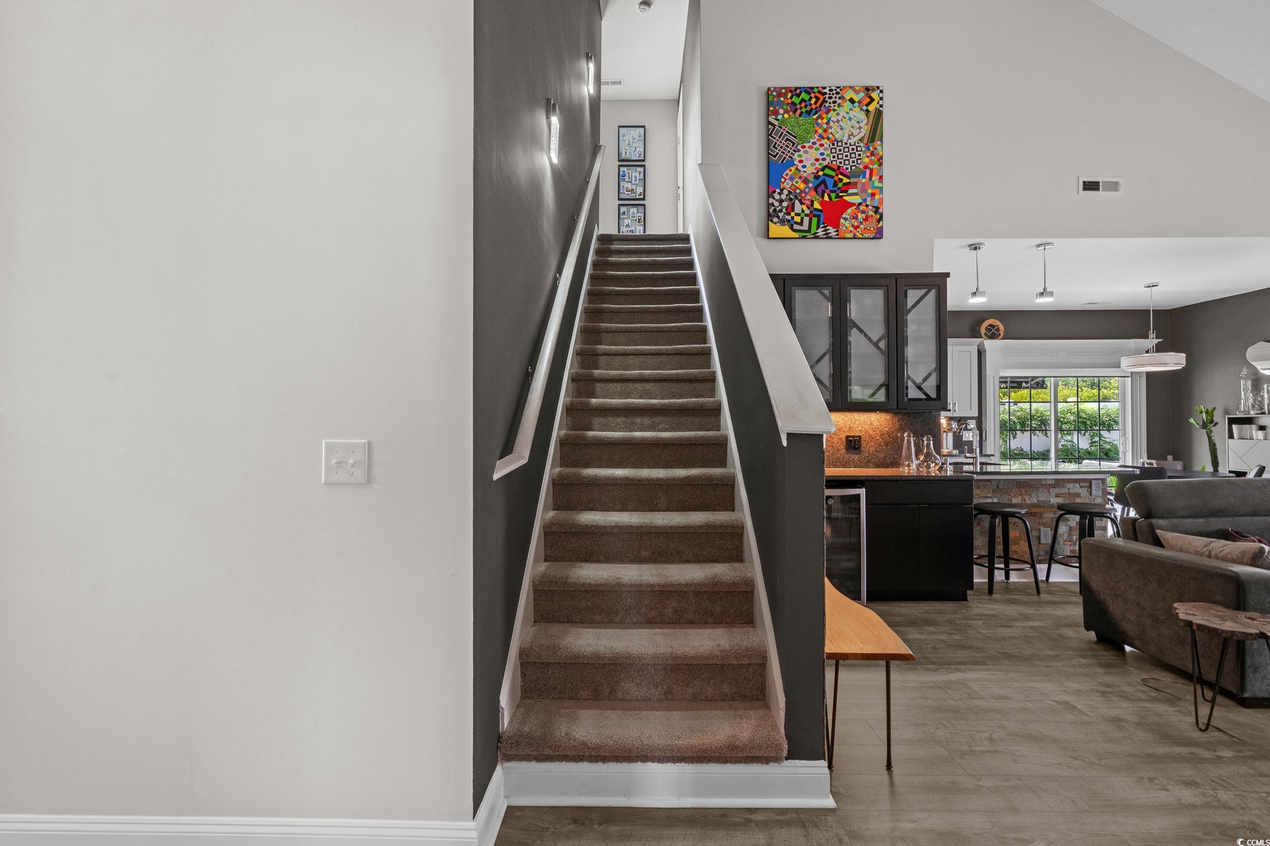 752 Hobonny Loop Longs, SC 29568 - Photo 24 of 40 Staircase with wood finished floors, wine cooler, and high vaulted ceiling