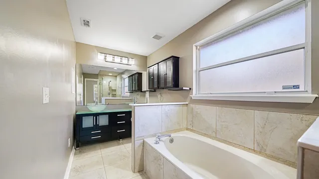 a bathroom with a tub sink and mirror