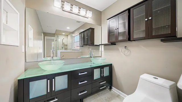 a bathroom with a sink a large mirror and a toilet