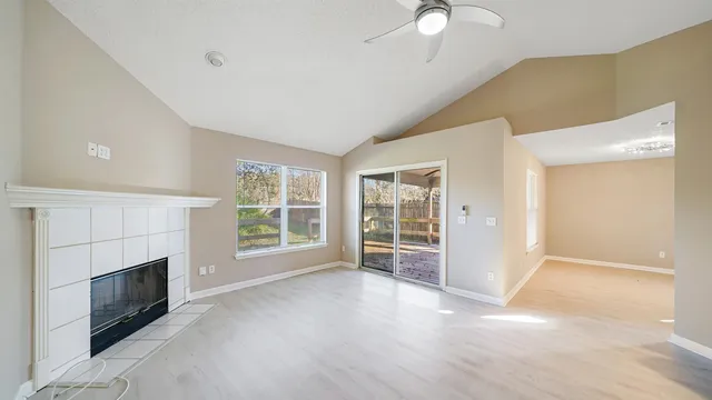 a view of an empty room with a fireplace and a window