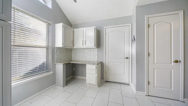 a view of a kitchen with white cabinets